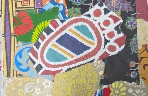 A colorful collage of various patterned paper pieces, including geometric shapes, florals, and gold accents, layered against a dark background.